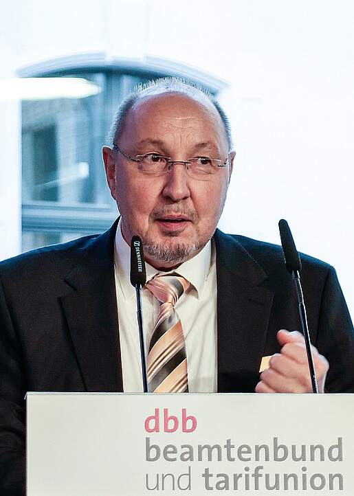 Ein Mann steht an einem Rednerpult und spricht in ein Mikrofon. Es handelt sich um Heini Schmitt, neuer dbb Fachvorstand Beamtenpolitik
