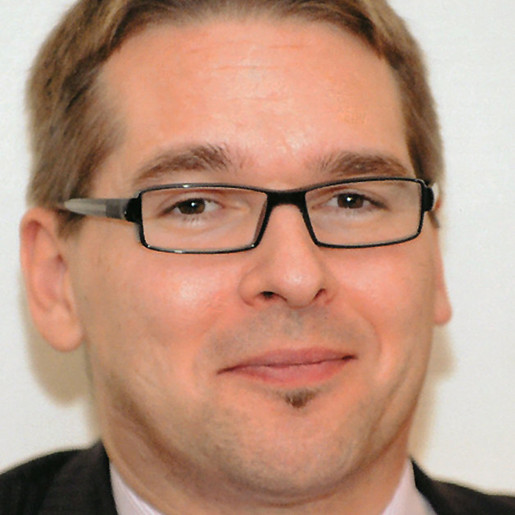 Lars Michaelis Ein Portrait von einem lächelnden Mann mit Brille