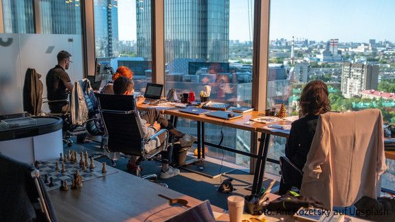 Sozialpartner verabschieden Leitlinien gegen Gewalt am Arbeitsplatz Menschen an einem modernen Arbeitsplatz vor Laptops