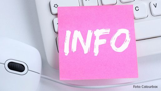 Auf einer weißen Computertastatur klebt ein Zettel mit der Aufschrift Info. 
