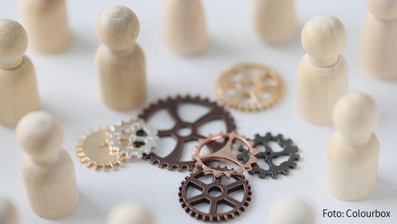 Abschlussbericht der Initiative für einen handlungsfähigen Staat Wooden figures of people with metal gears close up. Hire personnel, team building, teamwork concept. People connection in business.