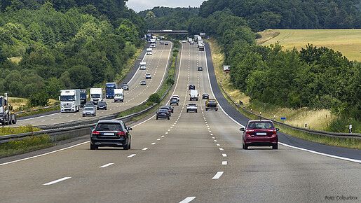 Das Foto zeigt Autos von hinten auf einer dreispurigen Autobahn.