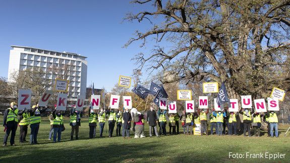 BBW Kundgebung Stuttgart Eine Gruppe von Menschen steht auf einer Grünfläche und protestiert. Sie halten Schilder hoch die zusammen gesetzt "Zukunft nur mit uns" darstellen