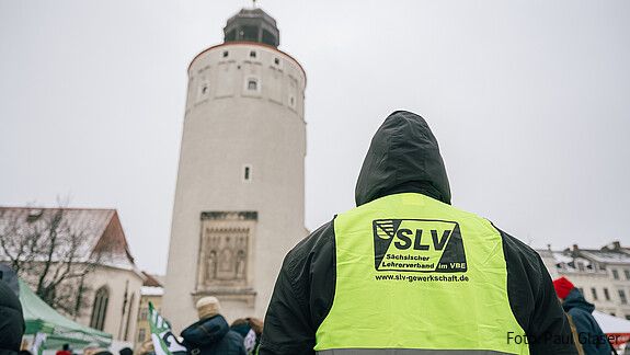 Menschen in gelben Warnwesten protestieren auf einem öffentlichen Platz