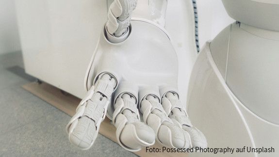 Stellungnahme zum Aktionsplan der Europäischen Kommission für den Kontinent der Künstlichen Intelligenz  Nahaufnahme einer weißen Roboterhand