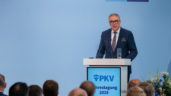 Fotos der PKV Jahrestagung 2025 am 05.06.2025 in Berlin  Ein Mann in Anzug steht hinter einem Rednerpult und spricht in ein Mikrofon