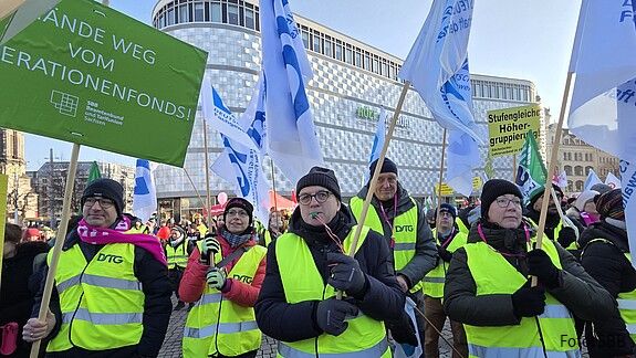 Menschen in gleben Warnwesten demonstrieren auf einem öffentlichen Platz