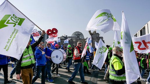 Demonstrierende Laufen mit Pauken und bunten Fahnen durch die Berliner Innenstadt