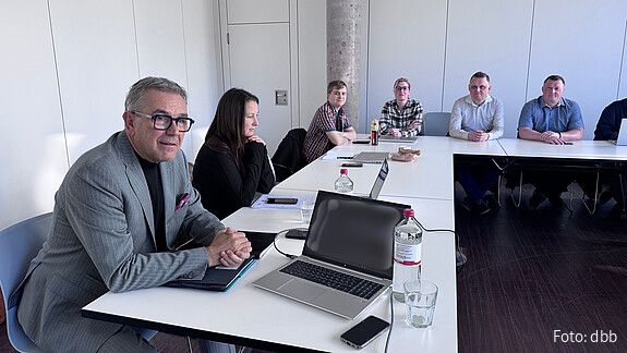 Menschen sitzen in einem Seminarraum und diskutieren