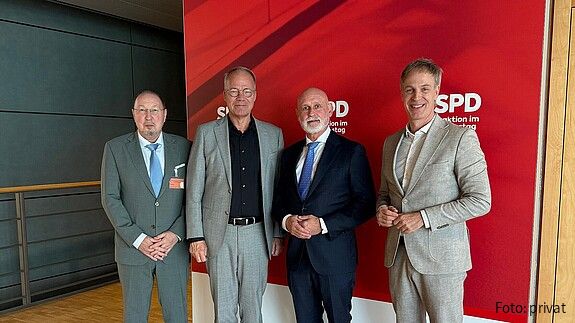 Gruppenfoto von vier Männern in Anzügen